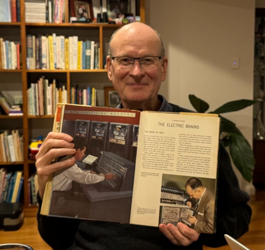 Bob holding the encyclopedia that inspired his interest in computers